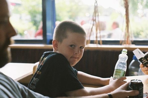 Un niño con una botella mira a la cámara - Window Light for Portraits