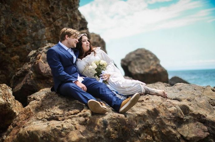 Una pareja de recién casados ​​recostados en las rocas de la playa: consejos para la fotografía de eventos