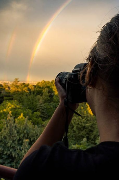 Una persona fotografiando un arcoíris.