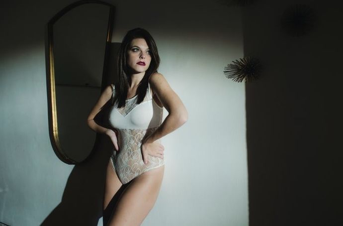 Una chica posa para una sesión de fotos de boudoir nupcial