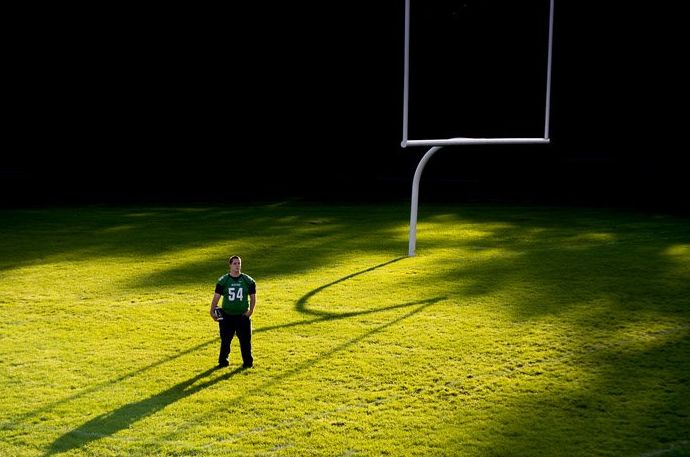 Foto de un hombre parado en medio de un campo de fútbol con una iluminación espectacular