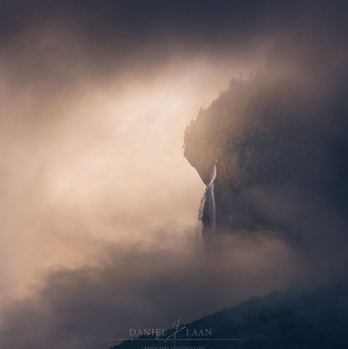 Una fotografía de paisaje de bellas artes espeluznante y dramática de una montaña rocosa rodeada por un cielo tormentoso y nublado.