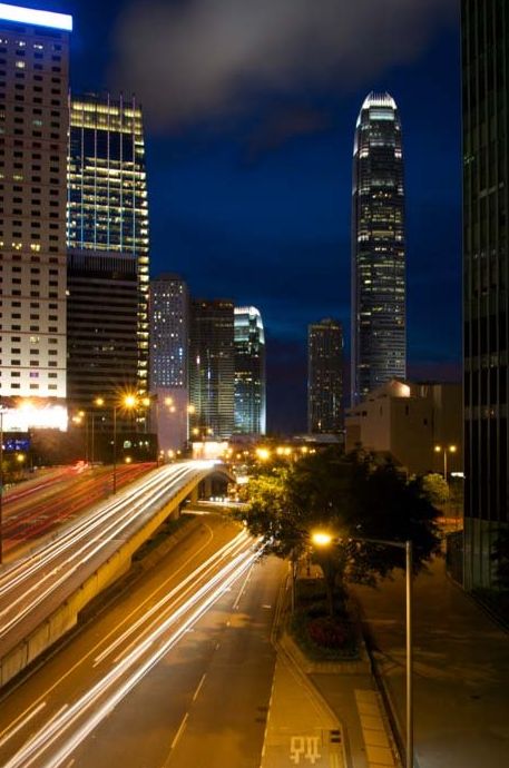 Foto de larga exposición de rascacielos por la noche con estelas de luz del tráfico