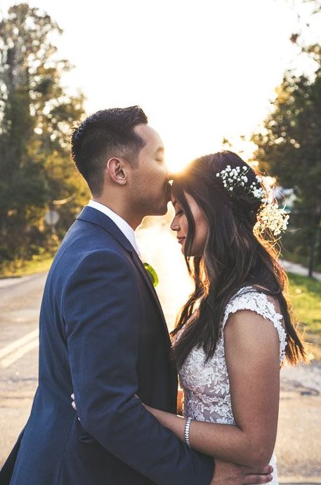 Una pareja de recién casados ​​besándose al aire libre capturada con fotografía estroboscópica