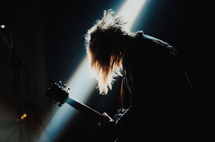 Una imagen de fotografía de concierto de un guitarrista en el escenario.