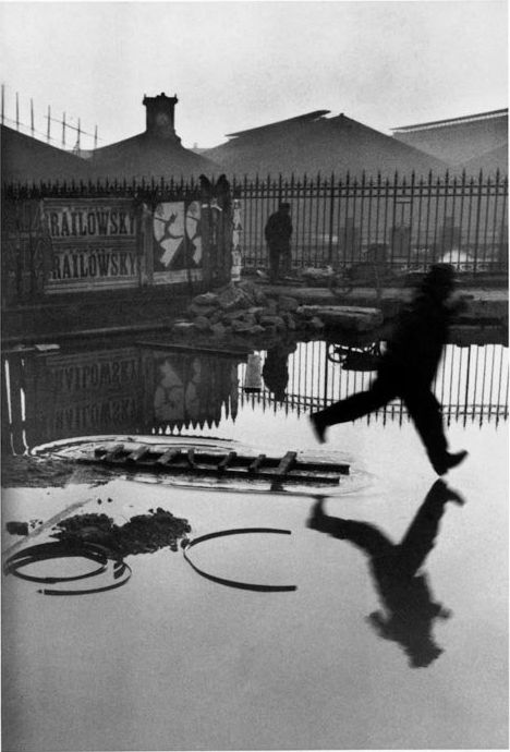 Una fotografía de Henri Cartier-Bresson de un hombre saltando en un charco - técnicas de composición